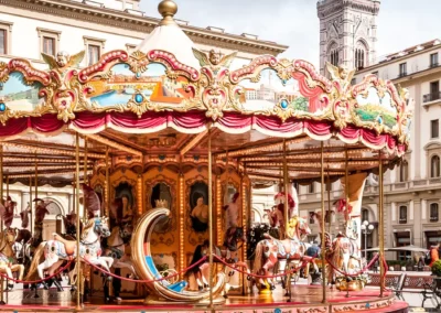 Carrousel coloré sur une place urbaine.