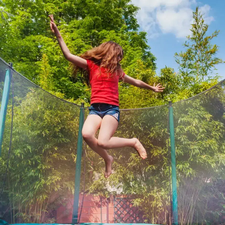 Jeune fille sur un trampoline Enfant sautant sur un trampoline en plein air.